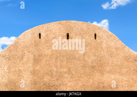 Close-up di un edificio di adobe in Nuovo Messico in una giornata di sole con un cielo blu sopra. Foto Stock