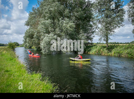 In canoa sul fiume Waveney Norfolk (riva destra), Suffolk (riva sinistra. Vicino a serratura Geldeston, Norfolk. Foto Stock