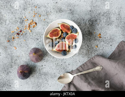 Una sana prima colazione. Ciotola di oat granola con yogurt, mirtilli freschi e figure Foto Stock