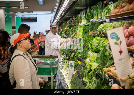 Gli acquirenti e i lavoratori nel reparto prodotti nel nuovo Whole Foods Market nel quartiere di Harlem a New York il giorno di apertura Venerdì, 21 luglio 2017. Il negozio di Harlem è la catena del XII store per aprire in città. Il negozio potrà trasportare circa 20 marchi di articoli realizzati localmente in Harlem. (© Richard B. Levine) Foto Stock