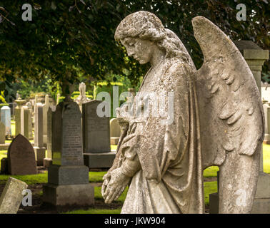 Antico in pietra scolpita con angelo chino, e triste espressione luttuoso, St Mary Collegiata cimitero, Haddington, East Lothian, Scozia, Regno Unito Foto Stock