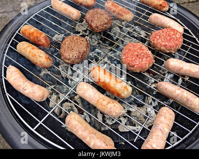 Barbecue di carne alla brace - salsicce e hamburger di manzo Foto Stock