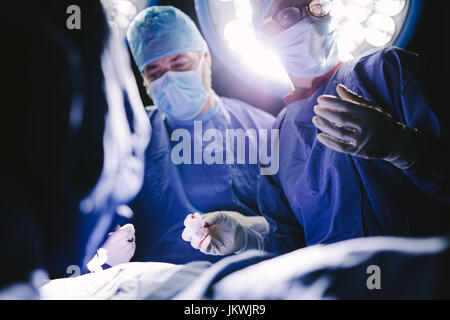 I professionisti del settore medico durante un intervento chirurgico in sala operatoria. Gruppo di chirurghi in ospedale il funzionamento del teatro. Foto Stock
