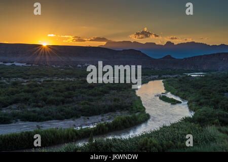 Raggi di sole su Chisos delle montagne e del Fiume Rio Grande al tramonto Foto Stock