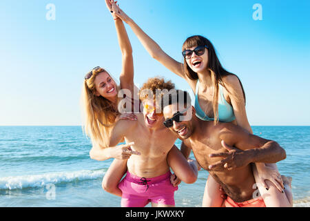 Allegro giovani amici godendo di estate sulla spiaggia Foto Stock