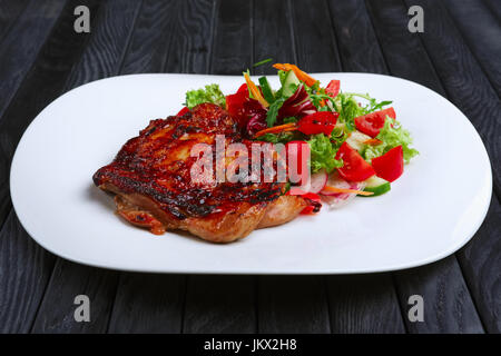 Succosa e croccante tritati fritto di maiale alla griglia con verdure fresche (cavolo rosso, pomodoro, il cetriolo, la carota e il peperone) Foto Stock