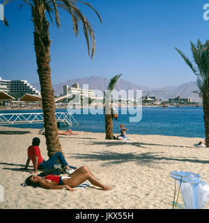 Urlauber am Strand von Eilat, Israele 1980er Jahre. I turisti alla spiaggia di Eilat, Israele degli anni ottanta. Foto Stock