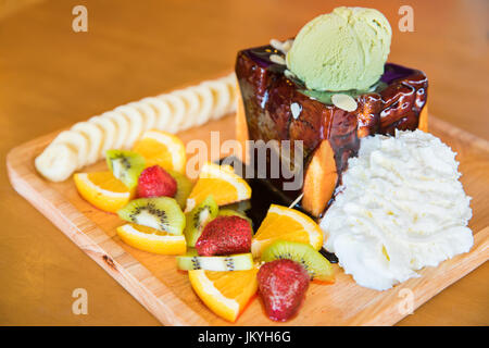 Toast al miele e panna montata con salsa di cioccolato, frutta e gelato Foto Stock