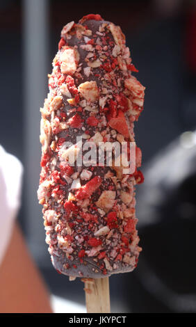 Congelati cioccolato banana anabbaglianti pop coperto con dadi e zuccherini Foto Stock