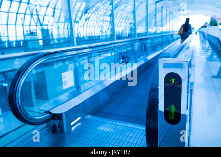 Concetto di viaggio. Escalator cammino interno moderno aeroporto terminale. Immagine in colori blu Foto Stock