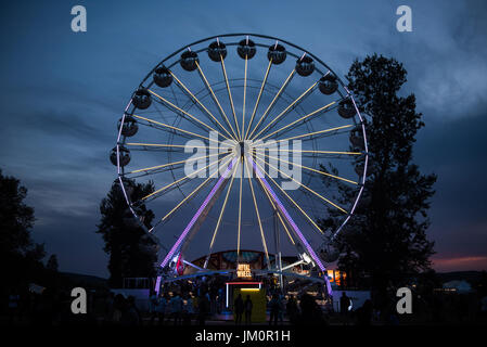 BONTIDA, Romania - 14 luglio 2017: la gente del castello elettrico festival godendo di un giro di notte sulla ruota panoramica gigante Foto Stock