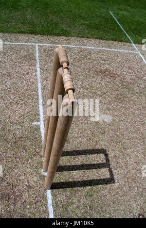 La vista dall'alto di un wicket di cricket che getta un'ombra in una giornata di sole, sorprende sempre la nostra visione che il wicket non è praticato sul prato. Foto Stock