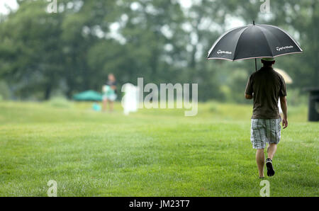 Silvis, Iowa, USA. 12 Luglio, 2017. Una ventola cammina con il suo ombrello per mantenere la leggera pioggia lontano vicino al ottavo foro, Mercoledì, 12 luglio 2017, durante il John Deere Classic Pro-Am a TPC Deere Run in Silvis. Credito: John Schultz/Quad-City volte/ZUMA filo/Alamy Live News Foto Stock