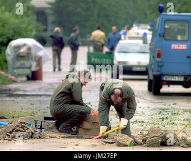 FILE - un file immagine datata 29 giugno 1996 mostra due specialisti della Bundeswehr esaminando il cratere in asfalto dopo un attacco di mortaio contro il 28 giugno 1996, nella motivazione dell' esercito britannico della caserma del Quebec a Osnabrück, Germania. La versione di prova di un presunto membro dell'IRA, per tentato omicidio, inizia a Osnabrück il 26 luglio 2017. Il 48-anno vecchio è sospettato di essere coinvolto nel 1996 attacco di mortaio contro la Caserma inglese. Foto: Ingo Wagner/dpa Foto Stock