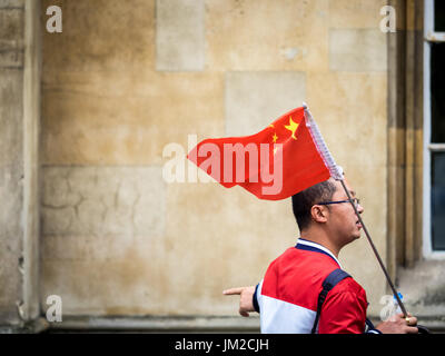 I turisti cinesi di Cambridge - una guida turistica di identificazione dei colloqui di bandiera al suo partito tour nel centro storico di Cambrdige REGNO UNITO Foto Stock