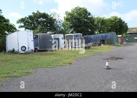 Raccolta di vecchie scatole di cavalli e di rimorchi in deposito presso un centro equestre nel West Sussex, Regno Unito Foto Stock