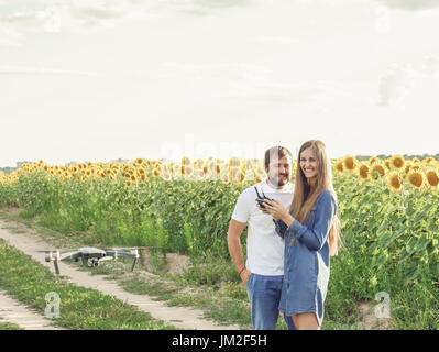 L uomo e la donna flying drone all aperto in campagna. Foto Stock