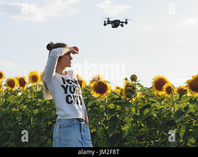 Bella giovane donna facendo selfie e posa su un mini drone Foto Stock