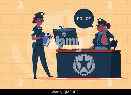 Due African American Police le donne che lavorano su computer che indossano uniformi guardie femmina blu su sfondo di mattoni Illustrazione Vettoriale