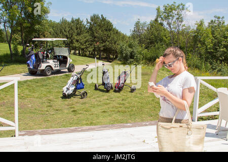 Giocare a golf o a giocare sul mio telefono? Foto Stock