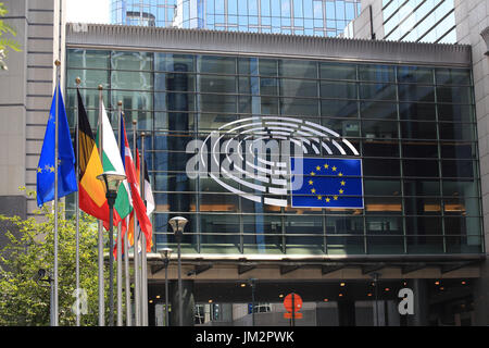 Bruxelles, Belgio - 17 Luglio 2017: Edificio del Parlamento europeo in una giornata di sole. Emblema del Parlamento europeo e nei paesi dell'UE bandiere. Foto Stock