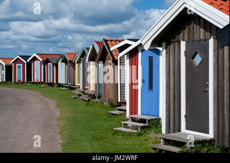 In legno colorato capanne sulla spiaggia, Norrebro Hamn, Skane, Svezia Foto Stock