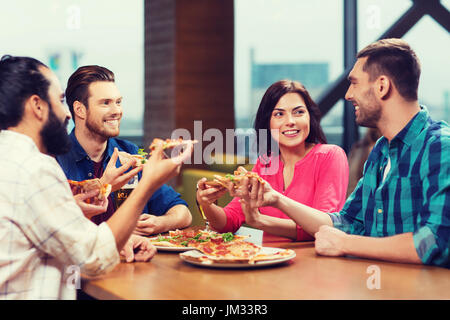 Gli amici di mangiare la pizza con la birra al ristorante Foto Stock