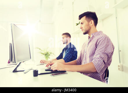 Uomo o designer con computer e tablet in ufficio Foto Stock