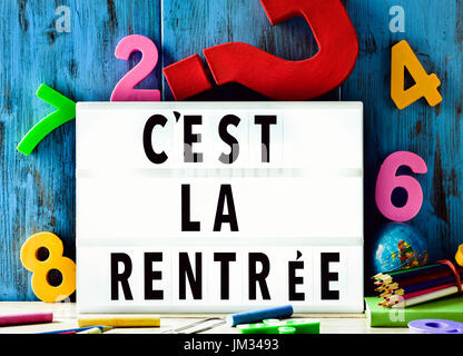 Il testo cest la rentree, torna a scuola in francese, in una lightbox posta contro un legno rustico sfondo, circondato da tre numeri dimensionali di un Foto Stock