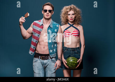 Uomo con gelato e donna con cocomero isolato su blu Foto Stock