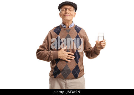 Soddisfatto senior con un bicchiere di acqua tenendo la sua mano sul suo stomaco isolato su sfondo bianco Foto Stock