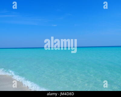 Spiaggia di sabbia a mare dei Caraibi nella città di Varadero a Cuba con acqua chiara sul mare paesaggio e palme esotiche e alberi e cielo blu chiaro nel 2017 al giorno. Foto Stock