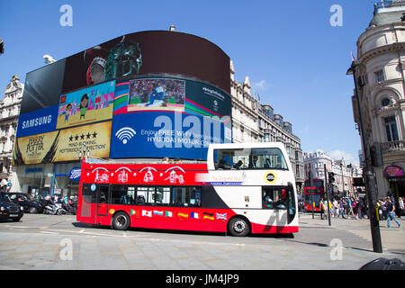 LONDON, Regno Unito - Agosto 12, 2016. sito vedendo passare bus grande schermo in piccadilly circus Foto Stock