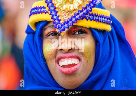 Edimburgo, Scozia - Luglio 16, 2017: primo piano di una femmina toothy performer con colorati copricapo durante il Carnevale del Jazz e Blues Festival Foto Stock