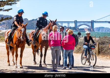 SAN FRANCISCO-SEPT 25, 2013: US Park poliziotti accolgono i visitatori a Crissy Field waterfront. Golden Gate Bridge in background. Foto Stock