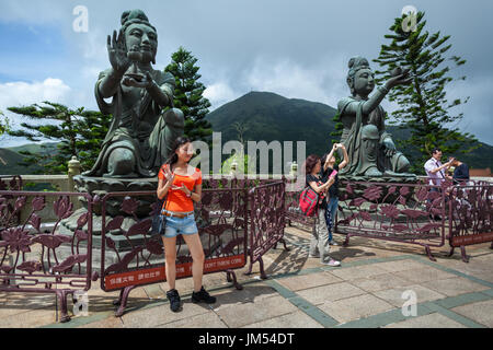 HONG KONG - Luglio 19, 2014: Statue di bronzo intorno al Big Buddha, Monastero di Po Lin, l'Isola di Lantau. I turisti sono scattare fotografie. Foto Stock