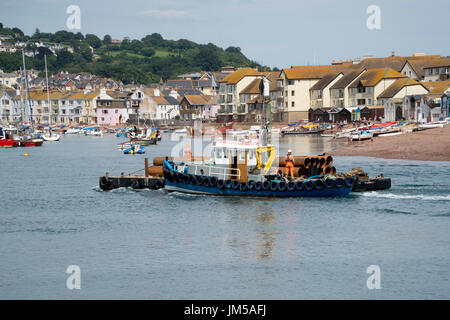 Barca di lavoro il trasporto di tubi di grandi dimensioni in Teignmouth visto dalla spiaggia di Shaldon, Devon, Inghilterra, Regno Unito Foto Stock