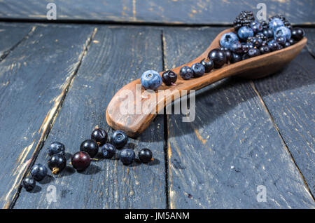 Le bacche sono stabiliti su un cucchiaio di argilla. Decorazione di frutti di bosco. Foto Stock