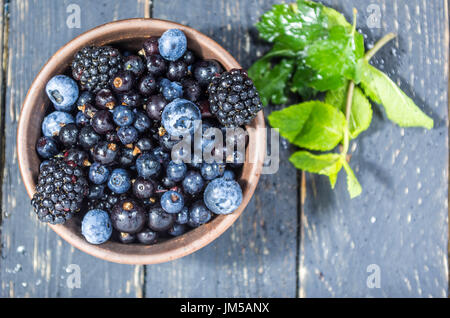 Frutti di bosco in una lastra di argilla. Bacche con gocce d'acqua. Con bassa profondità di campo. Berry decorazione. Foto Stock