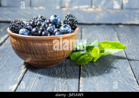 Dolce frutti di bosco in un vaso di argilla. Stile rurale. Foto Stock