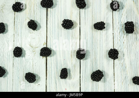 Blackberry sono disposti in una fila. Lay piatto. Frutti di bosco su uno sfondo bianco. Foto Stock