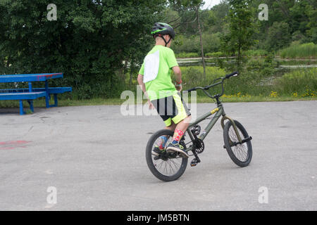 Ragazzo adolescente facendo trucchi sulla bicicletta durante la BMX concorrenza a Omemee giorni Foto Stock