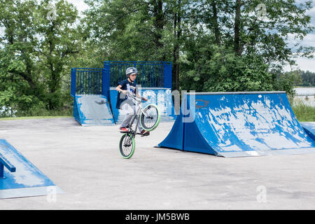 Ragazzo adolescente facendo trucchi spuntano un wheelie sulla bicicletta durante la BMX concorrenza a Omemee giorni Foto Stock