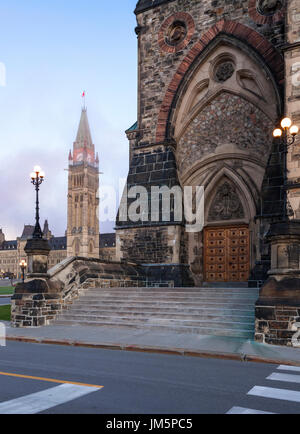 Il blocco West che è parte della collina del Parlamento con la torre della pace e tassello di centro sullo sfondo illuminato dal sorgere del sole mattutino a Ottawa. Foto Stock