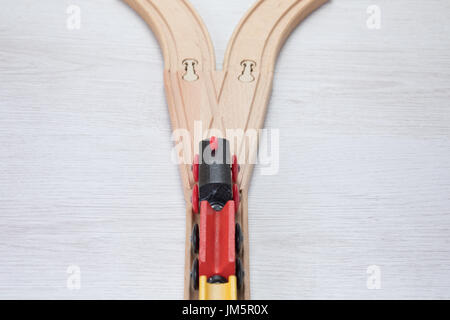 Colorato giocattolo di legno treno su un binario ferroviario visto dal di sopra come si avvicina una giunzione o la forcella di suddivisione in due direzioni concettuali scelta di un Foto Stock