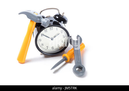 Elevato angolo di classic orologio sveglia con pila di giocattolo di plastica strumenti isolati su sfondo bianco con copia spazio, come concetto di tempo di manutenzione Foto Stock