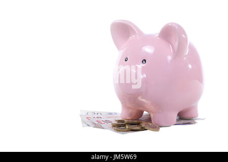Salvadanaio di rosa banca in piedi su una pila di sterling cash con monete e banconote isolato su bianco con copia spazio in un risparmio, investimenti e finanziaria Foto Stock
