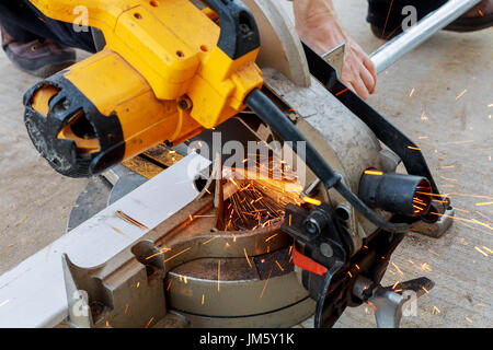 Close-up del lavoratore il taglio di metallo con la fresa. La formazione di scintille durante la rettifica di ferro. La bassa profondità della messa a fuoco Foto Stock