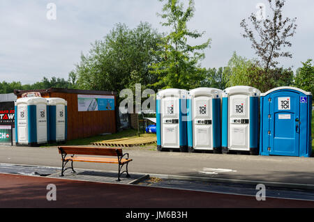 Una panchina nel parco posto direttamente di fronte i bagni portatili. La Polonia, l'Europa. Foto Stock