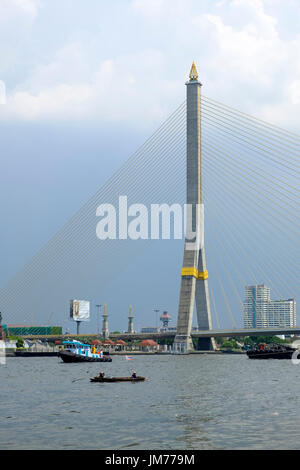 Barche vicino al pilone di cavo-alloggiato Rama VIII ponte che attraversa il fiume Chao Phraya, Bangkok, Thailandia. Foto Stock